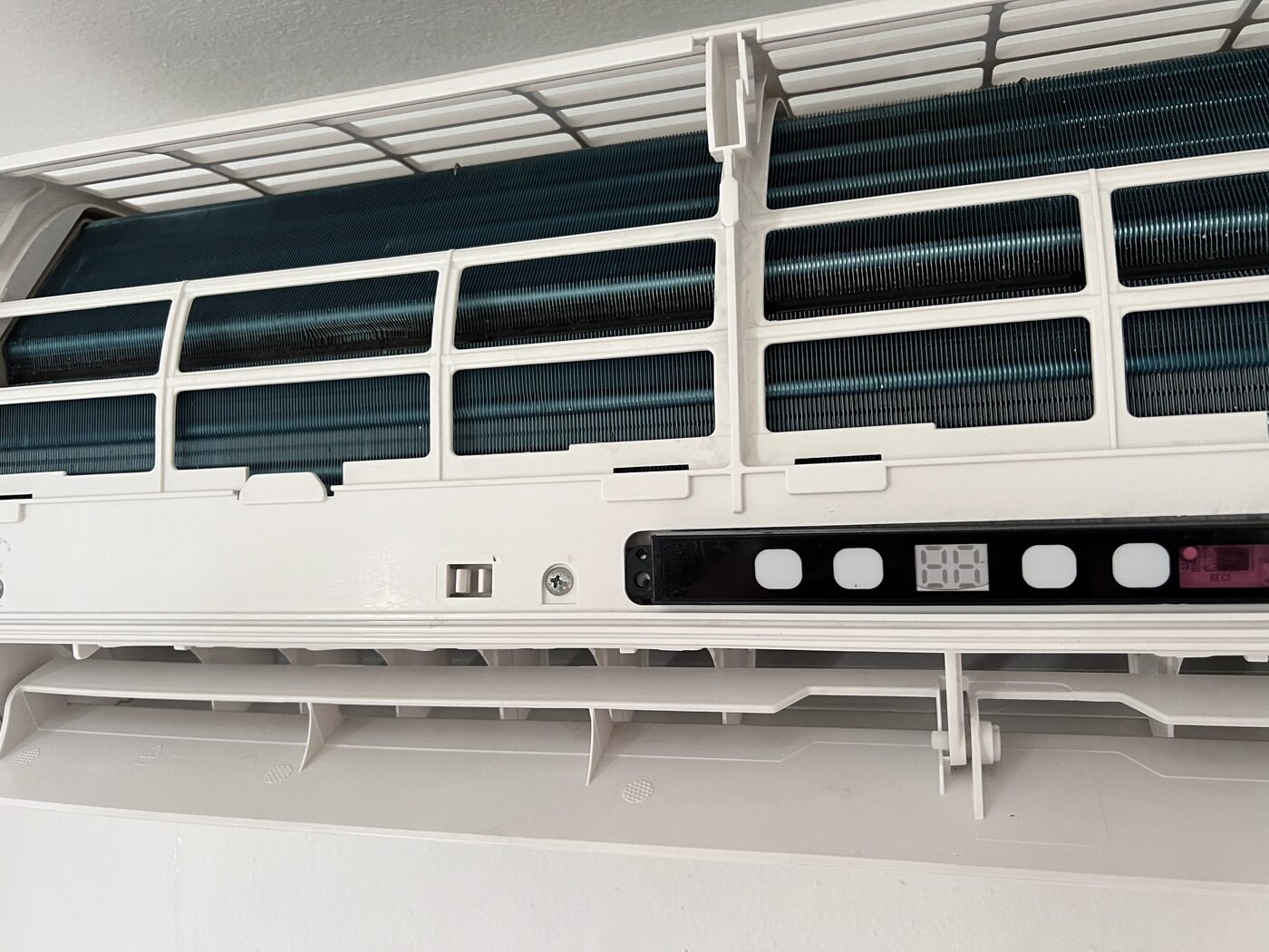 Clean AC unit interior after deep cleaning, showing restored blue-green evaporator coils and clear airflow path.